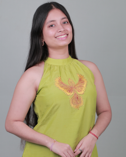 Woman wearing a green sleeveless top with a floral design on a gray background